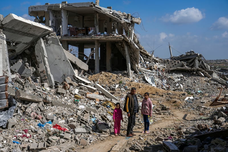 A Palestinian man and two girls stand amid rubble of homes destroyed by the Israeli army’s air and ground offensive against Hamas in in Bureij refugee camp, central Gaza Strip. Photograph: Abdel Kareem Hana/AP