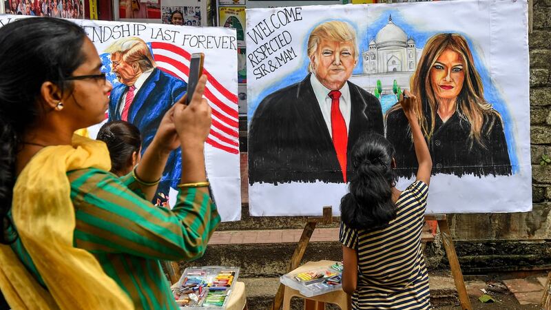 Students paint US president Donald Trump and his wife, Melania, in the street in Mumbai. Photograph: Indranil Mukherjee/AFP via Getty