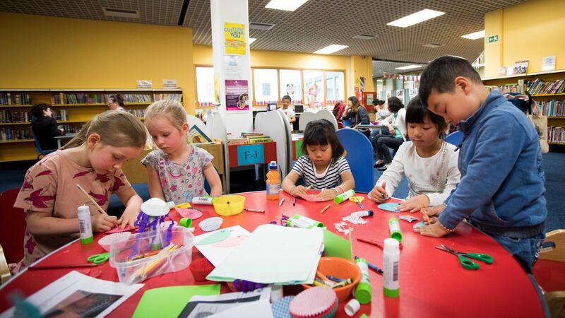 Sisters Juno Gallagher (6) and Ruth Gallagher (4), and family members Yan Lee (4), Leah Lee (8) and Kevin Lee (5) take part in craft workshop at library. Photograph: Tom Honan/The Irish Times