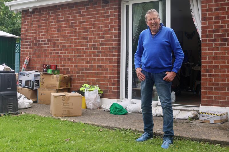 Michael Mills outside his home with sandbags at the doorway and some of the possessions he rescued from the flooding on Saturday morning.