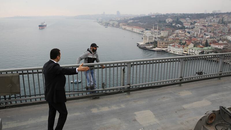 A security guard, part of Turkish president Recep Tayyip Erdogan security detail, speaks to a man standing behind of the Bosporus bridge barrier in Istanbul, on December 25th, 2015. Photograph: Yasin Bulbul/AFP