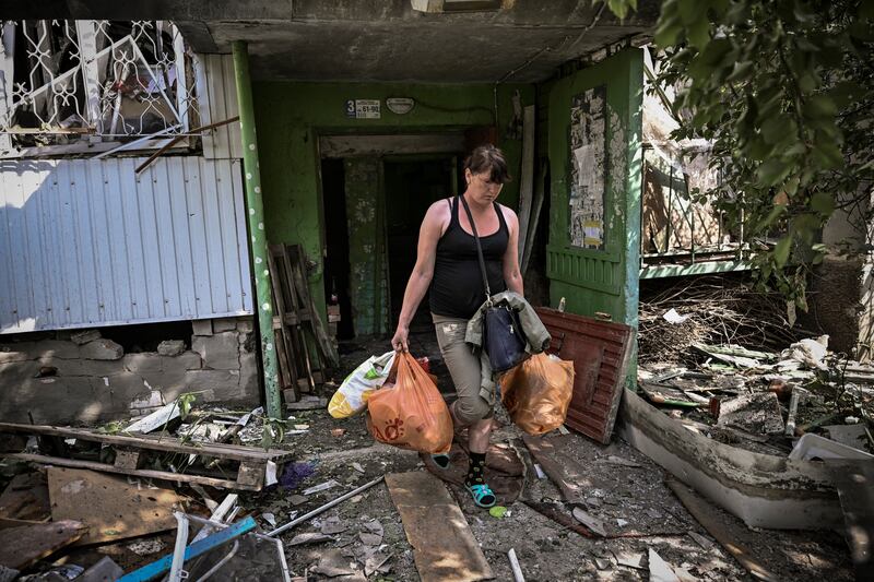 A woman walks out of a damaged apartment building after a strike in the city of Slovyansk at the eastern Ukrainian region of Donbas. Photograph: Aris Messinis/AFP via Getty