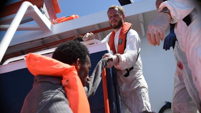 Sea rescue: rescue co-ordinator Will Turner helps a man aboard MY Phoenix, Médecins Sans Frontières’ rescue ship