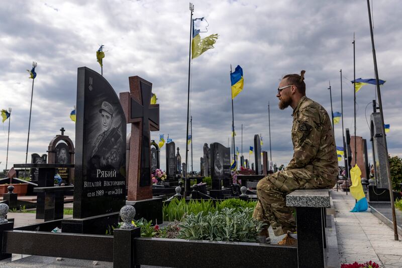 Ivan Lut, a Territorial Defense volunteer, in the veterans’ section of the cemetery in Chernihiv, Ukraine. Photograph: David Guttenfelder/The New York Times