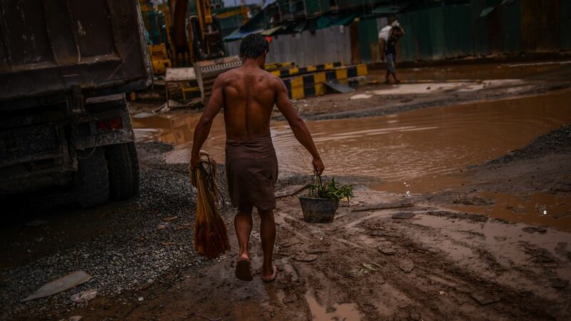 A construction worker heads back to his shipping container room after catching dinner in the Mekong river in April 2017. It’s not uncommon for labourers to live onsite, but conditions are poor and overcrowded. Photograph: Lauren Crothers