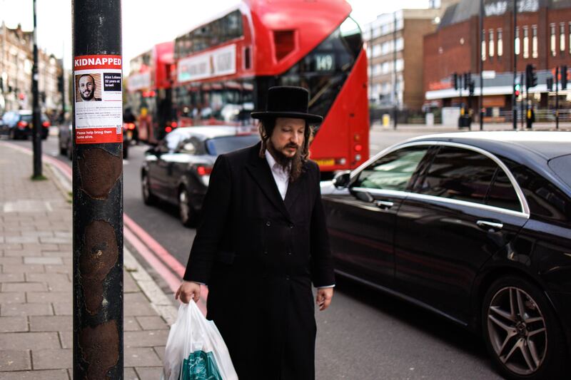 A member of London's Orthodox Jewish community walks past a flier showing a person kidnapped by Hamas during its attack on Israel, in the Stamford Hill area of London. Photograph: Tolga Ahmen.EPA-EFE