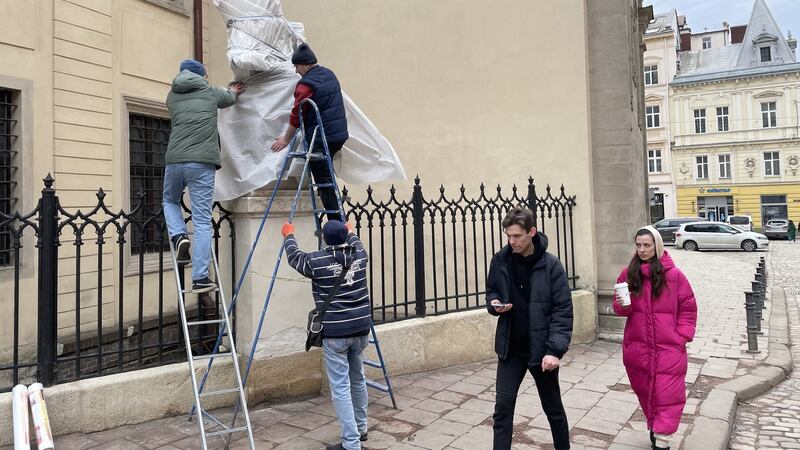 Workers in Lviv wrap up statues in the Unesco-listed old town amid fears of Russian bombing. Photograph: Daniel McLaughlin