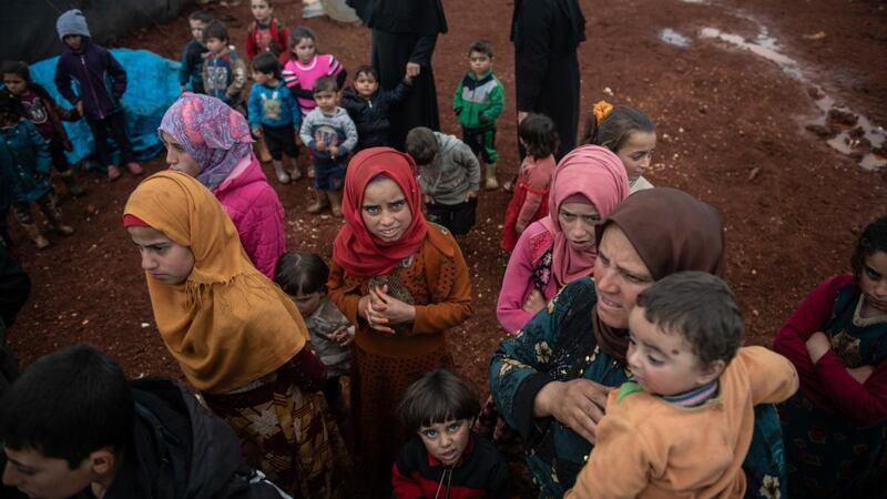 Displaced Syrian children wait to receive humanitarian aid supplied by Humanitarian Relief Foundation’s at Marabune camp in Idlib. Photograph:  Burak Kara/Getty Images