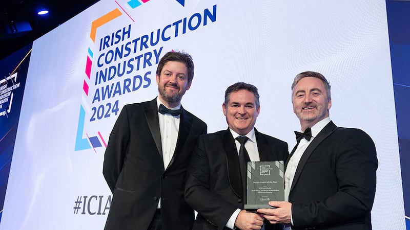 Gary O'Sullivan, construction director at Elliott Group, presents the design project of the year award to  Kevin Bates and Paul Connolly, STW Architects