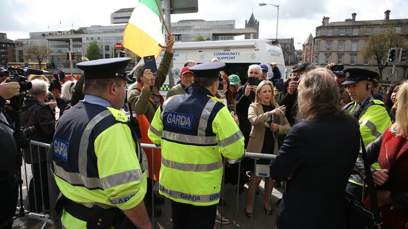 Gardaí speak to  Gemma O’Doherty, John Waters and their supporters outside the Four Courts in Dublin.  Photograph Nick Bradshaw