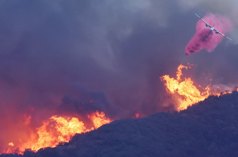 A firefighting aircraft drops the fire retardant Phos-Chek as the Palisades Fire burns. Photograph: Mario Tama/Getty Images