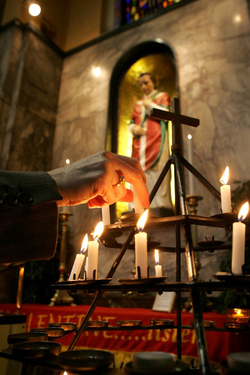 A woman lighting a candle at the St Valentine shrine at at Whitefriar Street Church in Dublin. Photograph: Cyril Byrne