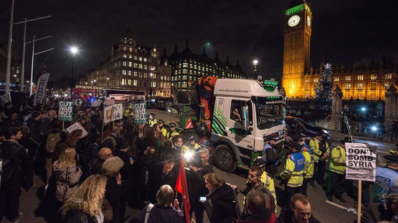 Police  surround a truck after a demonstrator stopped it, and climbed underneath, during a protest outside the Houses of Parliament in central London  against the British government’s proposed involvement in air strikes against the Islamic State  group in Syria.  Photograph:   Chris Ratcliffe/AFP/Getty Images