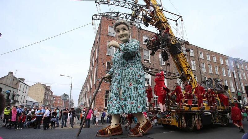 Crowds watch as performers from the French arts group Royal de Luxe take to the streets of Limerick with their Giant Grandmother parade as part of this years city of culture celebrations. Photograph: Niall Carson/PA Wire.