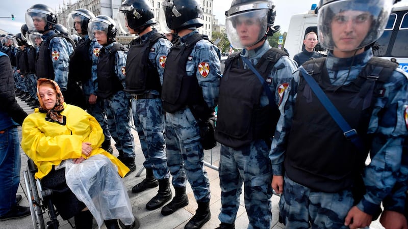 A woman at a rally in Moscow, with servicemen of the Russian National Guard. Photograph: Alexander Nemenov/AFP/Getty Images