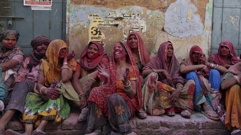 Hindu devotees laugh as they watch the religious festival of Lathmar Holi, where women beat the men with sticks, in the town of Barsana in the Uttar Pradesh region of India. Photograph: Cathal McNaughton/Reuters