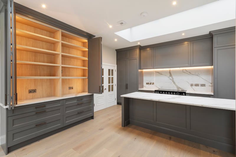 The kitchen is smart and unfussy, with floor-to-ceiling grey units