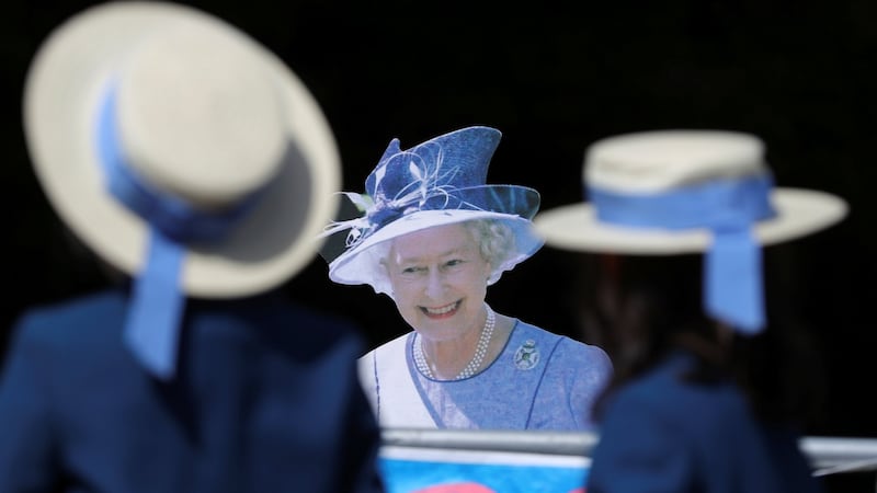 Schoolgirls walk past a cardboard cutout of Queen Elizabeth near Windsor Castle,  on Friday. Photograph: Marko Djurica/Reuters