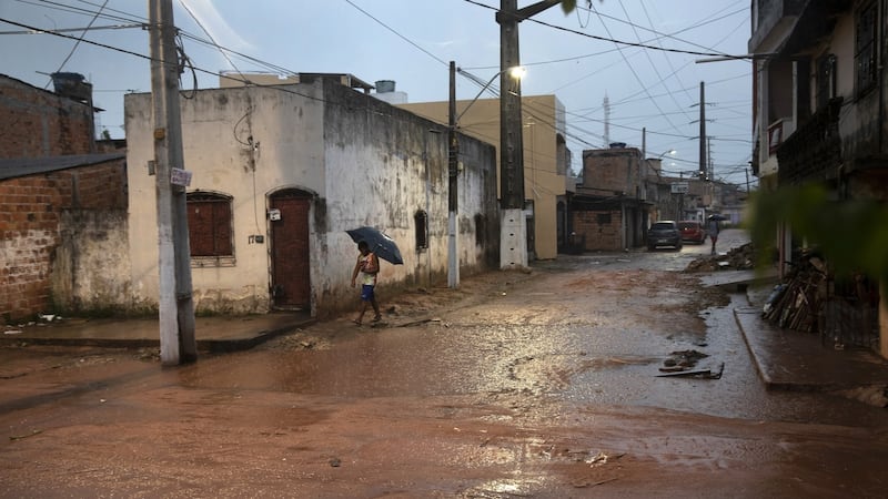 Eduardo Chaves (16) was gunned down on this corner in 2014, by the wall where the man with the umbrella is walking in Belém. Photograph: Tyler Hicks/The New York Times