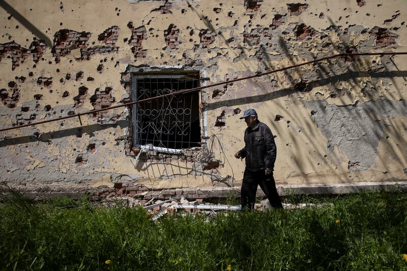 A resident walks past a damaged apartment building in Siversk, a town near Bakhmut. Photograph: Tyler Hicks/The New York Times