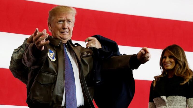 “Greatest threat”: a soldier helps Donald Trump put on a flight jacket for his speech to US troops in Japan. Photograph: Jonathan Ernst/Reuters