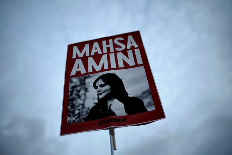 A woman holds a placard with a picture of Mahsa Amini during a protest against her death in Berlin in September 2022. Photograph: Markus Schreiber/AP