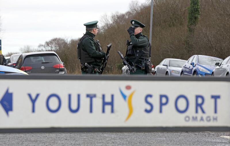 Armed police officers stand guard at the scene of a shooting of an off duty policeman  at the Killyclogher Road sports complex in Omagh. Photograph: Paul Faith/AFP 