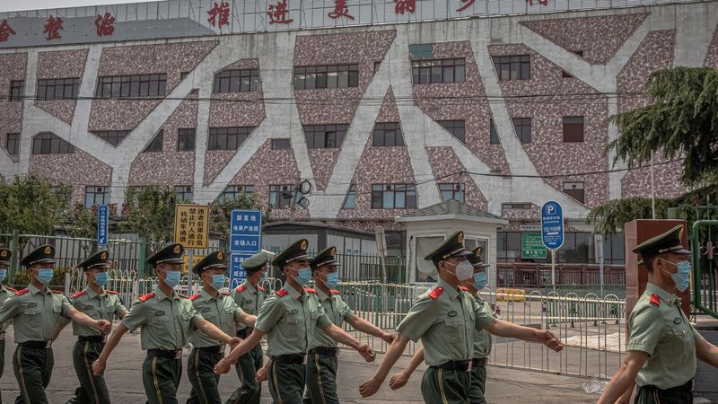 Chinese soldiers wearing face masks march next to the building of the closed Xinfadi market, in Fengtai district, Beijing, China, June 13th 2020. Photograph: Roman Pilipey/EPA