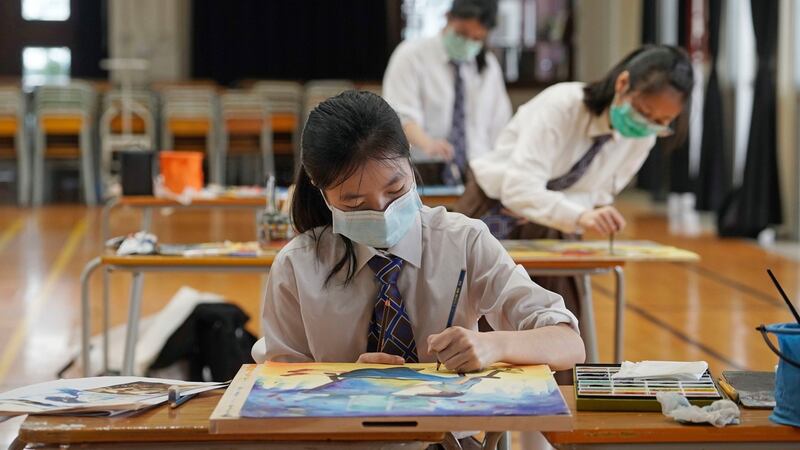 A  student wearing a mask takes part in a final secondary school exam in Hong Kong. Photograph: Kin Cheung/AP