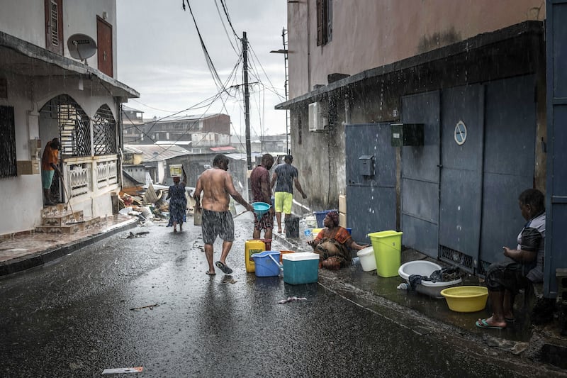 Residents collect water during a downpour in Mamoudzou. Photograph: Sergey Ponomarev/The New York Times