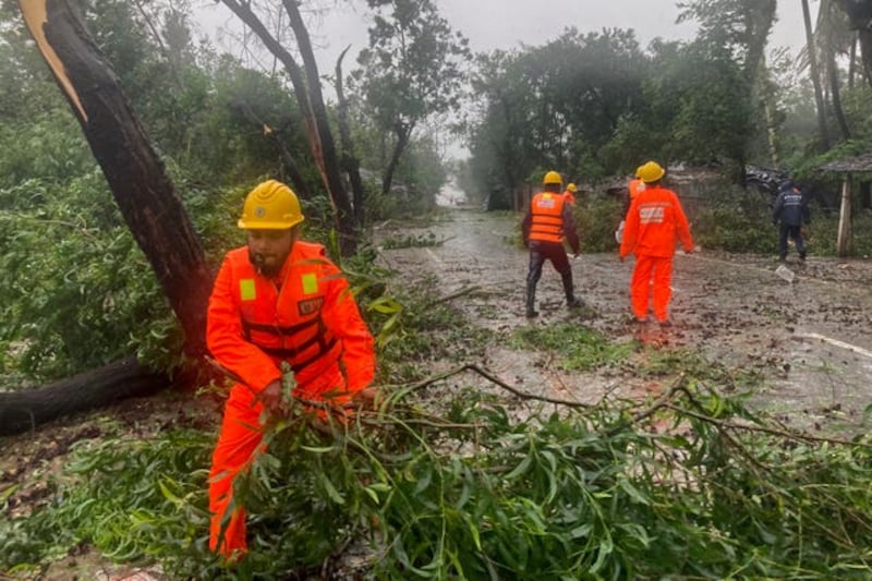 Rescue workers clear debris from the storm. Photograph: AP