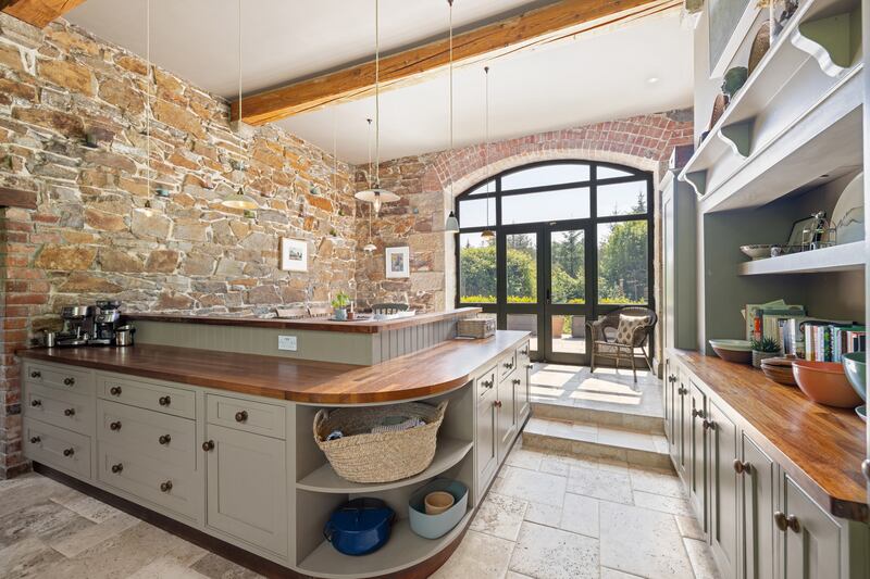 The kitchen has exposed stone walls and overhead beams. Photographs: Andrew Nolan