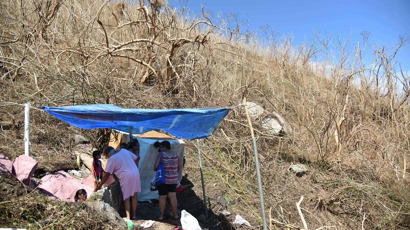 People  bathe in a spring covered with  a tarpaulin  on a hillside  in Yabucoa, eastern Puerto Rico, in the wake of damage caused by Hurricane Maria.  Photograph: Hector Retamal/AFP/Getty Images