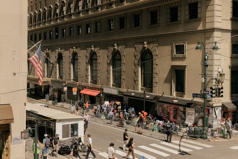 Migrants waiting to be processed queue outside of the Roosevelt Hotel in Manhattan. Photograph: Jeenah Moon/The New York Times
                      