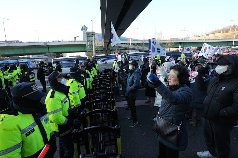 Supporters of Mr Yoon staging a rally as police officers stand guard. Photograph: Lee Jin-man/AP