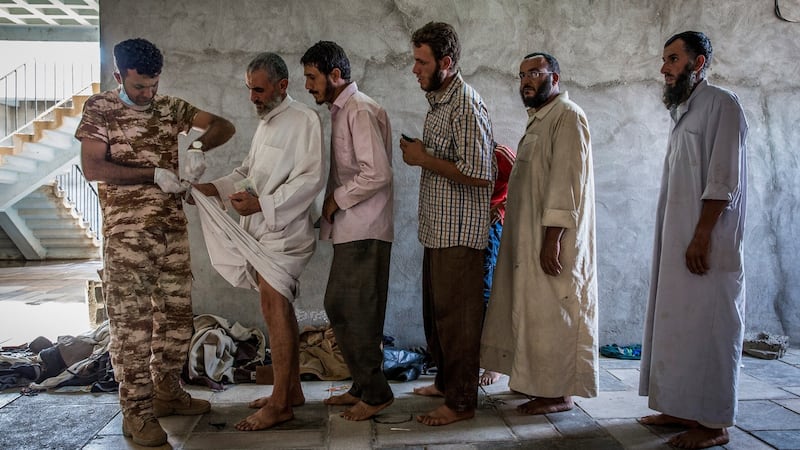 Men suspected of being Islamic State fighters are searched at a security screening centre near Kirkuk, Iraq, on October  1st. Photograph:  Ivor Prickett/The New York Times