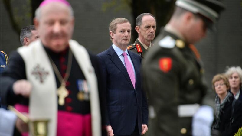 Taoiseach Enda Kenny watches Auxiliary Bishop of Dublin Raymond Field, blessing the graves at the memorial during the annual 1916 commemoration.