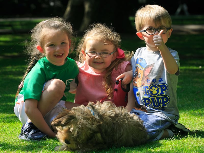 (From right) Phoenix Berry (5), Molly Richardson (4) and Max Berry (3) from Dublin e with Bowie the dog enjoying the good weather in St Stephens Green in Dublin. Photograph: Collins