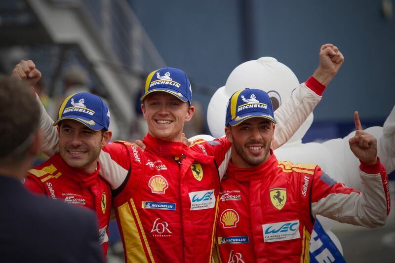 (From left) Ferrari 499P Hybrid Hypercar WEC's Spanish driver Miguel Molina, Danish driver Nicklas Nielsen and Italian driver Antonio Fuoco celebrate after winning the Le Mans 24-hours endurance race. Photograph: Guillaume Souvant/AFP via Getty Images