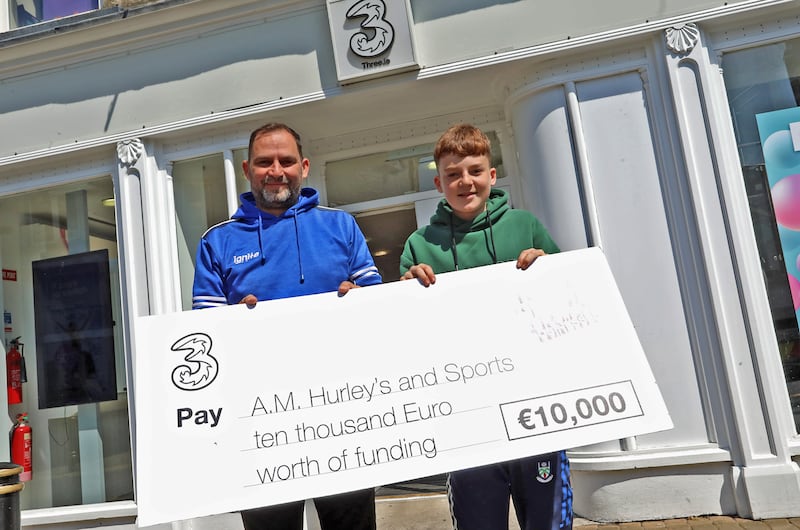 Aidan Morgan with his son Kéalan and his Three Grant for Small Businesses cheque outside the 3 store in Monaghan. Photograph: Lorraine Teevan