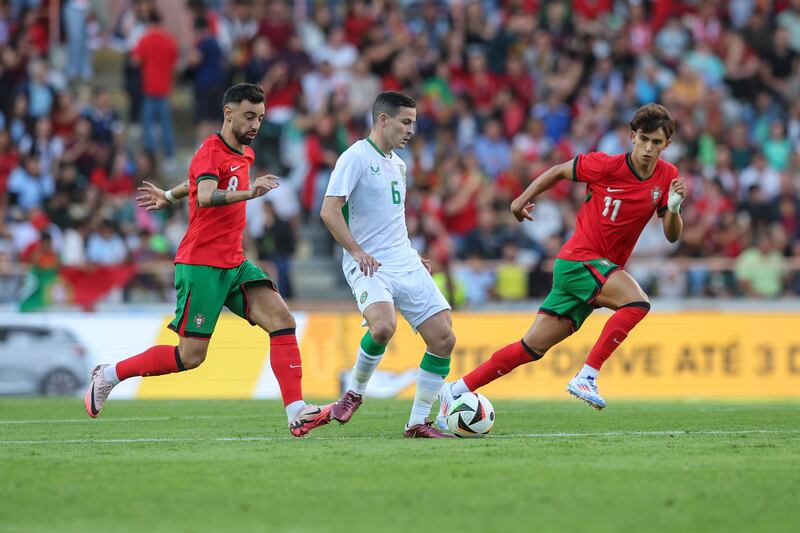 AVEIRO, PORTUGAL - JUNE 11: Josh Cullen of Republic of Ireland (C) tries to escape Bruno Fernandes of Portugal  (L) during the International Friendly match between Portugal and Republic or Ireland at Estadio Municipal de Aveiro on June 11, 2024 in Aveiro, Portugal. (Photo by Carlos Rodrigues/Getty Images)