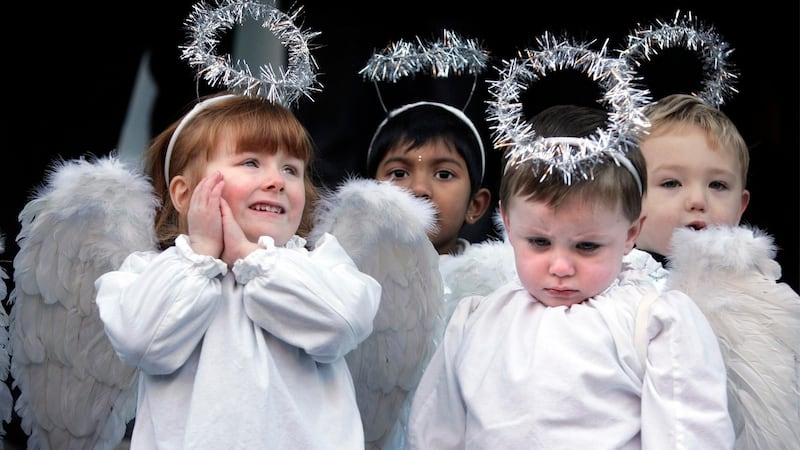 Paris Curtis (left) is featured on the new Christmas Stamp from An Post. She was photographed in 2010 with Alan Fox (right) and with Elinsa Rose Varghese, and Bobby Atkinson (behind) among the children from St. Josephs Nursery, Maryland, Dublin 8. Photograph: Dara Mac Dónaill/The Irish Times