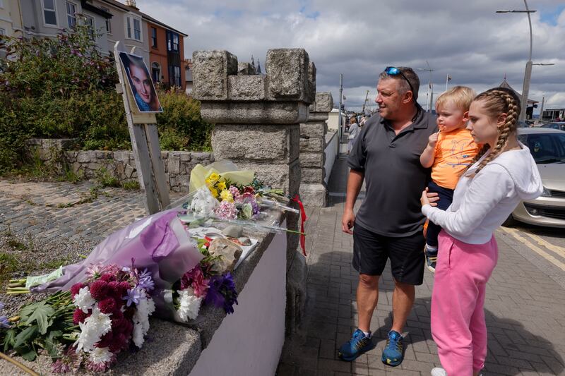 Willie Braine with his daughter Hally and grandson Zac, from Shankill, pay tribute at the former home of singer Sinead O’Connor in Bray on Thursday. Photograph: Alan Betson/The Irish Times

