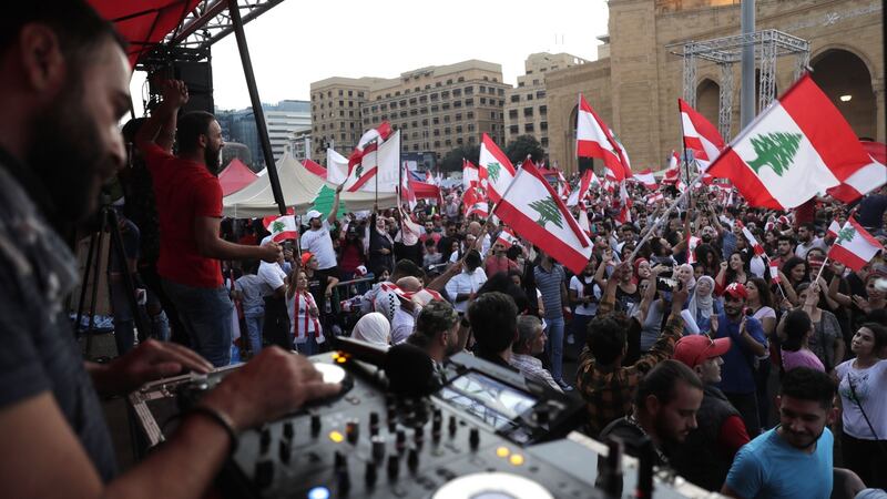 A Lebanese DJ plays music as demonstrators wave national flags at the Martyrs’ Square in the centre of Beirut. Photograph: Anwar Amro/AFP via Getty Images