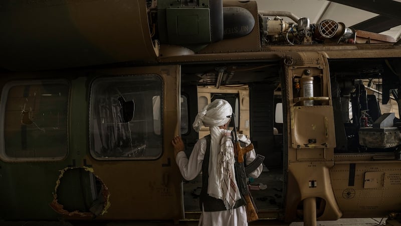 A Taliban member inspects a damaged helicopter at the airport in Kabul on Tuesday.  Photograph: Victor J Blue/The New York Times