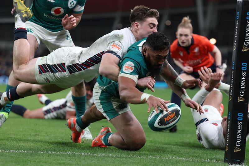 Ireland's Bundee Aki scores a try despite the attempt of England's Tommy Freeman to keep him out. Photograph: Billy Stickland/Inpho