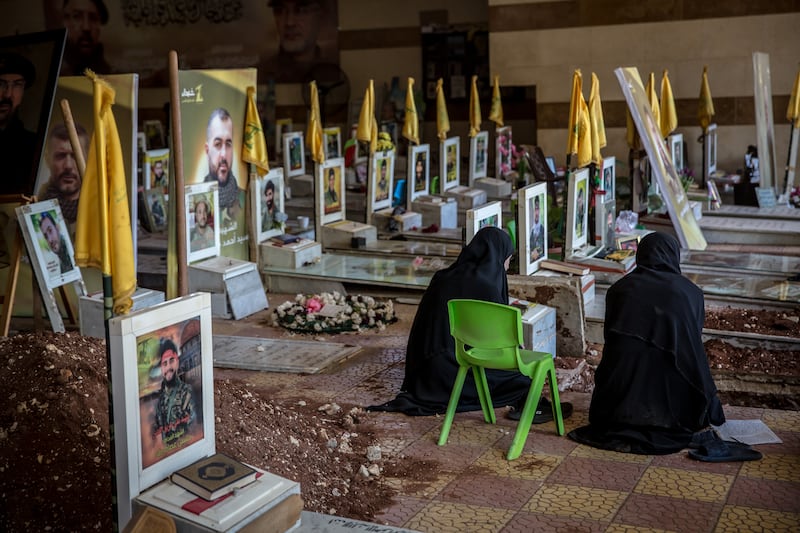 Women sit by a grave at a Shia cemetery in Beirut's southern suburbs, where many Hezbollah fighters have been buried. Photograph: Sally Hayden