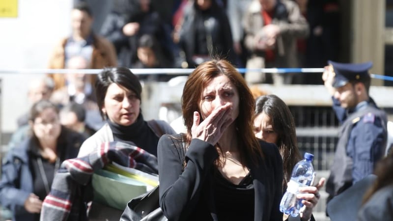 A woman cries as she is evacuated from the tribunal building in Milan after a shooting was reported inside a courtroom. Photograph: Luca Bruno/AP Photo