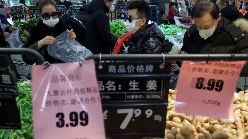 Customers wearing masks select vegetables in a supermarket in Beijing. Photograph: Wu Hong/EPA