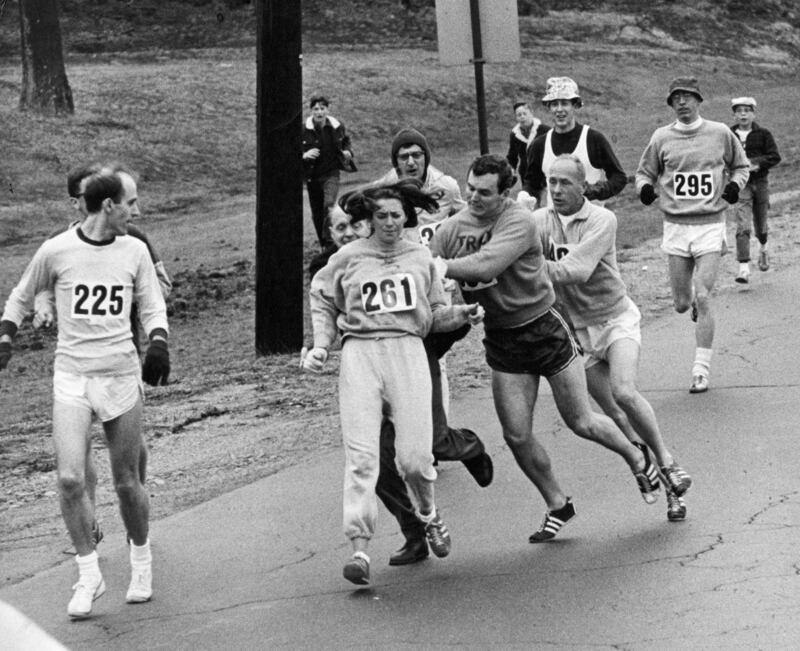 Kathrine Switzer running in the Boston Marathon in 1967 when runner Jock Semple tried to rip the number off her shirt and remove her from the race. Photograph: Paul Connell/The Boston Globe via Getty